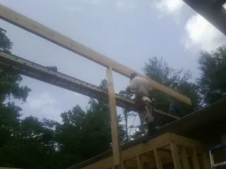 Carpenter setting a ridge beam over a new addition frame — Ice Dam Removal by Roofing Brothers in Wycombe