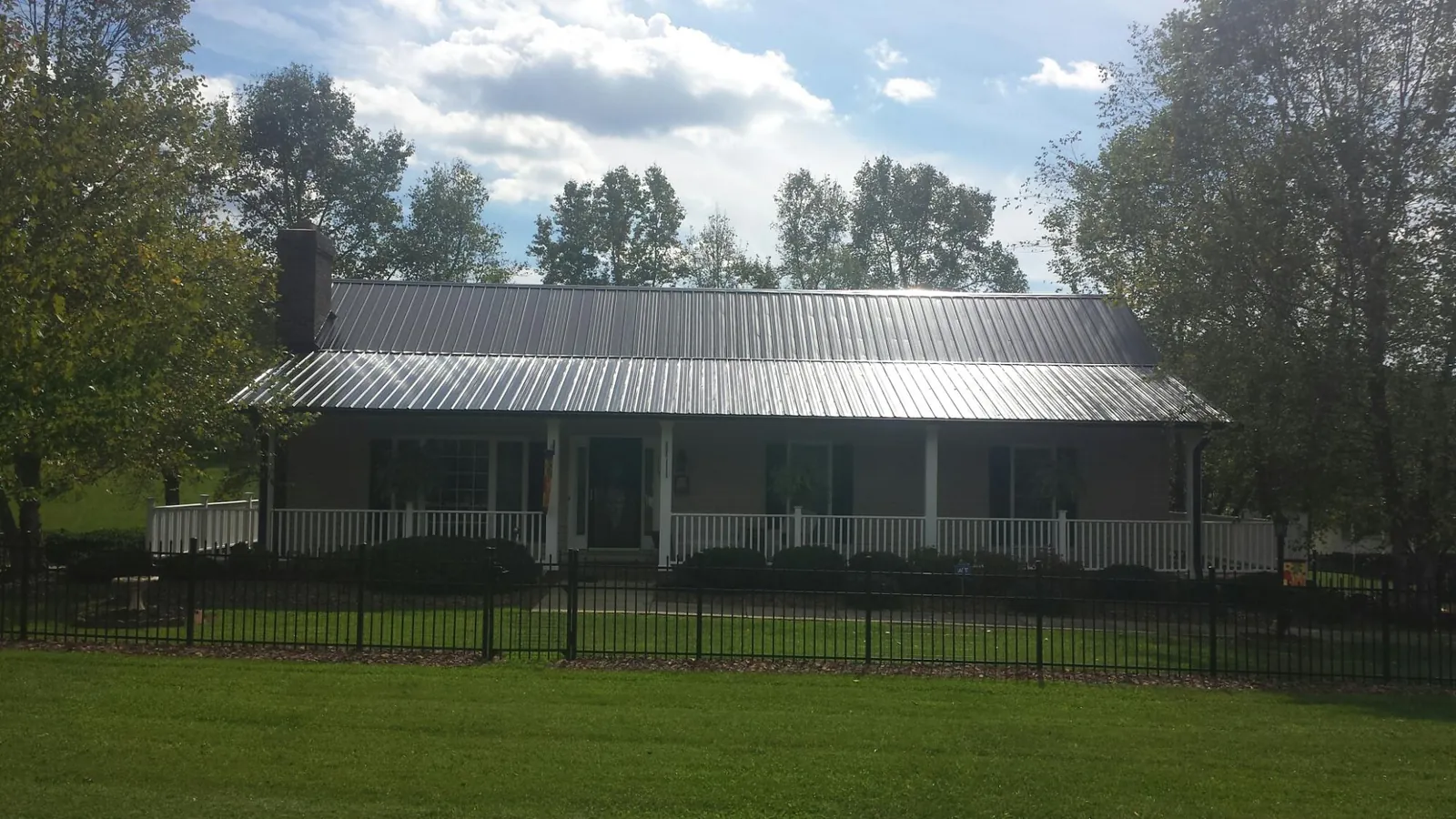 Gray metal roof on a brick ranch with a full width front porch — Gutter Guard Installation work by our crew in Wycombe